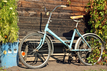 Naklejka na ściany i meble Old vintage bike. Retro bicycle standing at the wooden wall.