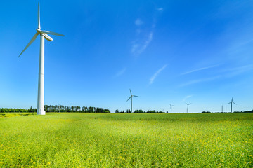Wind generator in the meadows, on a background of blue sky.