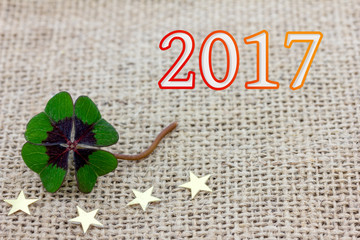 Glücksklee und Sterne liegen auf Stoff für Silvester 2017