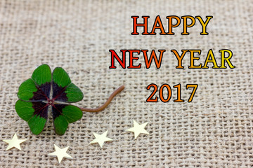 Glücksklee und Sterne liegen auf Stoff für Silvester 2017