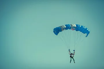 Photo sur Plexiglas Sports aériens Parachutiste Sur Parachute Coloré Dans Un Ciel Clair Ensoleillé.