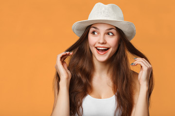 Surprised happy beautiful woman looking sideways in excitement, isolated on orange background