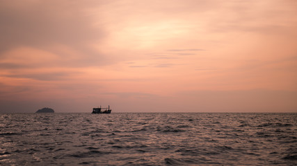 little boat in the sea with sunset