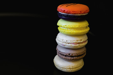 view from top point to vivid colored macaroons in stack on each other on black background/more free space/all in focus/landscape orientation