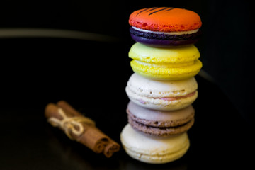 view from top point to vivid colored macaroons in stack on each other on black background/more free space/different focus point/landscape orientation