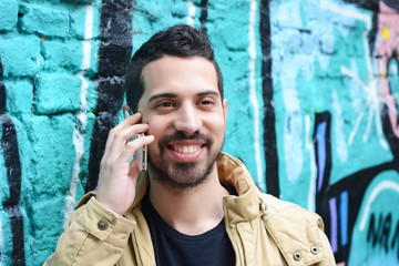 Young latin man talking on the phone.