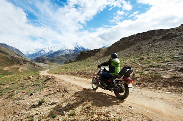 Fototapeta na wymiar Motorbike tourism. Traveller at motorcycle in mountains
