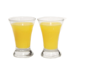 two shots with a bright yellow cocktail