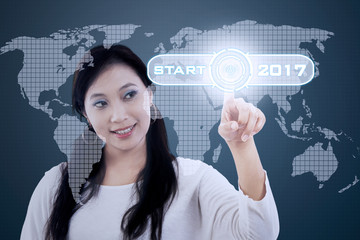 Woman touches virtual button with 2017