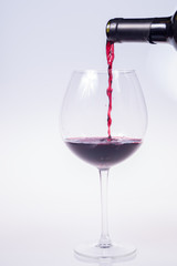 glass of red wine in the foreground on white background, isolated subject