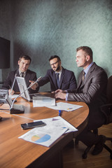 three business people having a meeting conference talking about future success of the company. modern city office interior
