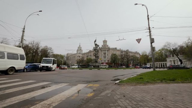 City Round Road Traffic. Vehicles Moving in a Circles, Turning, Going Off, Coming In. Zebra Crossing in Front. White Sky. Spring Time. Wide Shot