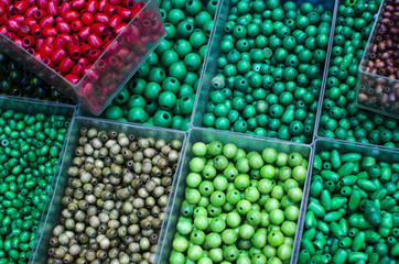 perles verte rouge vert de différentes tailles et couleurs dans des boites verte bleue 
