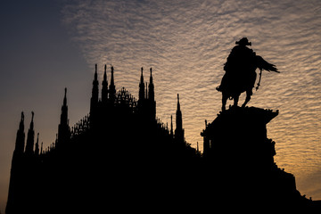 Milan Cathedral (Duomo di Milano) and Vittorio Emanuele II statue, Italy. Silhouette backlit.