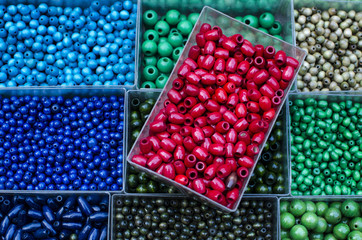 perles verte vert bleu bleue rouge de différentes tailles et couleurs dans des boites verte bleue 