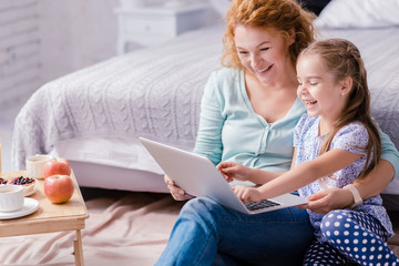 Girl sitting in front of the laptop with her grandmother