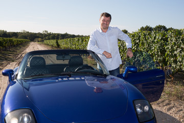 Businessman, winegrower, in his convertible blue car