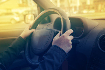 Female hands gripping steering wheel