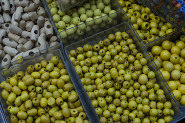 perles jaune bois de différentes tailles et couleurs dans des boites verte bleue 
