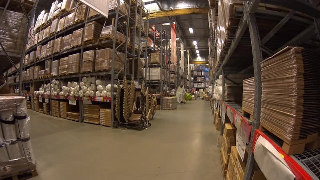 Warehouse employee wearing high visibility clothing moving away shopping cart