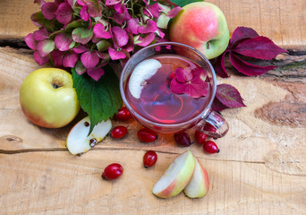 Still life with a cup of tea from rose hips and apples 