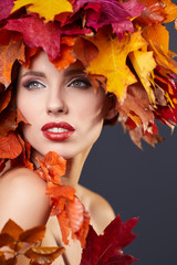 Woman with leafs on head in autumn concept.