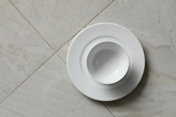 empty bowls, plates and cups on gray background