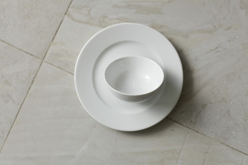 empty bowls, plates and cups on gray background