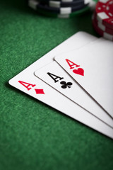 Playing cards and poker chips on green table