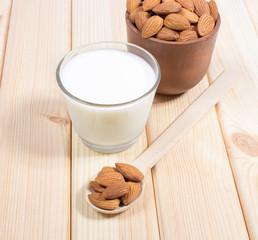 Almond milk with almond on a wooden table.