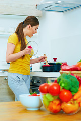 Smiling woman cooking in kitchen with fun.