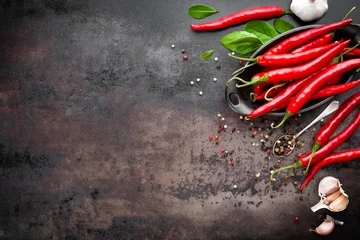 Fotobehang red hot chili pepper corns and pods on dark old metal culinary background © Sea Wave