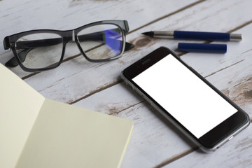 Smart phone and glasses on a wooden background