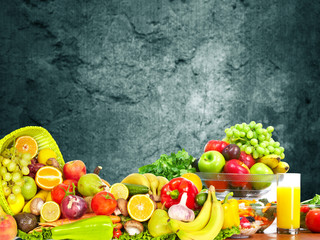 Vegetables and fruits over dark wall background.