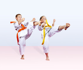Naklejka premium In karategi boy and a girl are beating kick leg