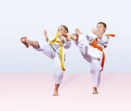 Girl and boy in karategi are beating blow leg