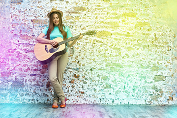 Obraz premium teenager style portrait of young woman playing acoustic guitar