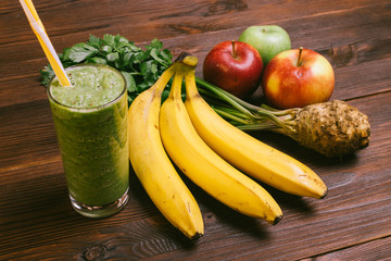 Green smoothie in a glass with a straw, bananas, celery root and
