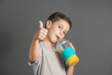 Little funny boy drinking a fresh juice through a straw © kleberpicui