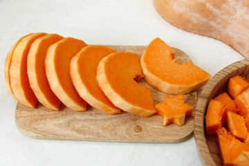 cut pieces of pumpkin on a wooden board.