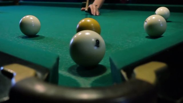 Young woman playing billiard