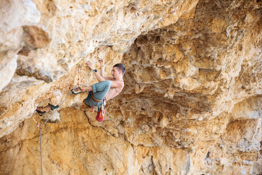 Male rock climber on a challenging route on a cliff