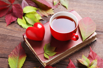 Autumn leafs with cup of tea on brown wooden table