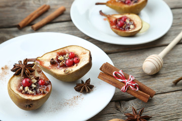 Baked pears with honey, walnuts and cranberries on grey wooden t
