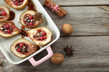Baked pears with honey, walnuts and cranberries on grey wooden t