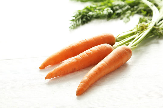 Fresh and sweet carrots on a white wooden table