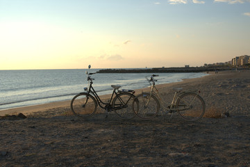Fototapeta premium Two bikes on the beach at dawn