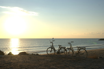 Fototapeta na wymiar Two bikes on the beach at dawn