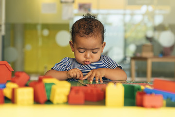 Happy baby playing with toy blocks.