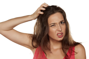 portrait of nervous young woman with itching in her hair